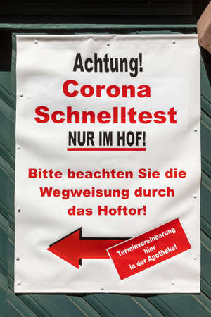 Hochheim, Germany - April 25, 2021: poster with german description of Corona Test. Text in english: attention Corona Test at tge court yard. please follow the arrow direction gate.For deadline contact pharmacy.のeditorial素材