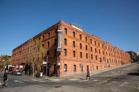 San Francisco, USA - May 17, 2022: people enjoy walk alomg Jefferson street with old brick building belonging to San Francisco National maritime museum in early morning.のeditorial素材