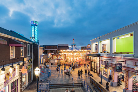 San Francisco, USA - June 5, 2022: Merry go round on the pier at night with open shops and vacation mood.のeditorial素材