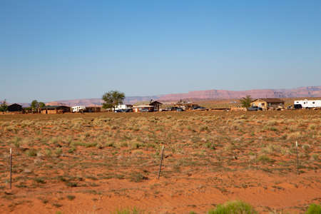 typical panoramic view to rural landscape with farm, fence and cars in the heat of Utahの写真素材