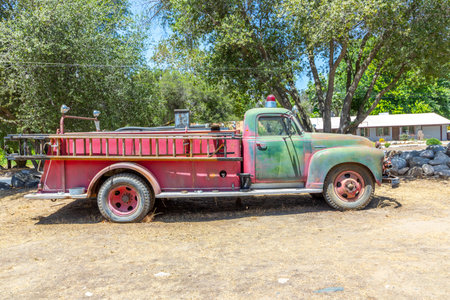 Three Rivers, USA - May 21, 2022: Old vintage dirty fire engine vintage car at an outdoor loam...