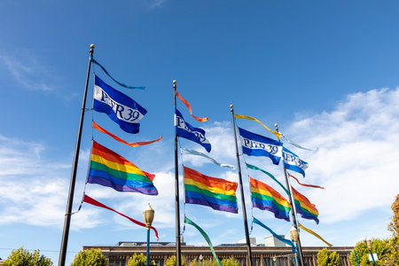 San Francisco, USA - June 7, 2022: flag of pier 39 and the rainbow flag for gay people fluttering in the wind..のeditorial素材