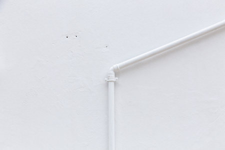 harmonic background of white painted plaster wall with water tubeの写真素材