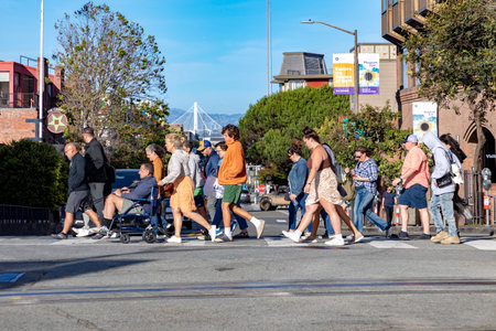 people crossing a street at a pedestrian crossing in San Francisco, United States.