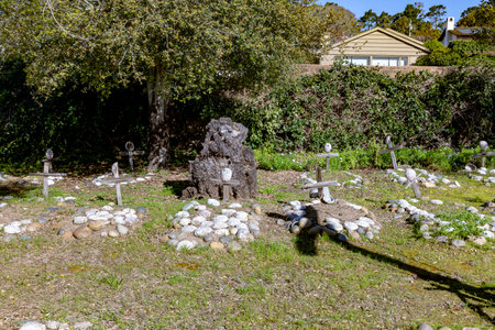Carmel, USA - March 15, 2019: Grave sites of native Americans - Indians - at the Carmel Mission are marked with stone circles and wooden crosses with abalone shells.のeditorial素材