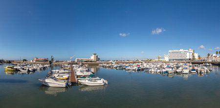 Faro, Portugal - October 3, 2020: harbor promenade with ships and motorboats and skyline of Faro, Portugal.のeditorial素材