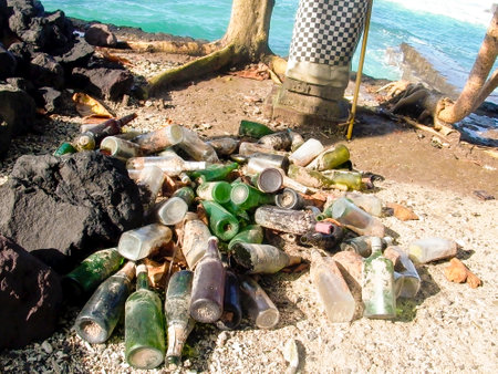 Candi Dasa, Indonesia - July 27, 2004: bottles after a party at the beach in Candi Dasa with a sacred palm tree.のeditorial素材