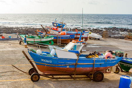 Famara, Spain - August 4, 2007: fishermen prepare the old wooden fishing boat for the next turn in...