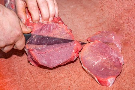 detail of hand of butcher, cutting the fresh fillet meat