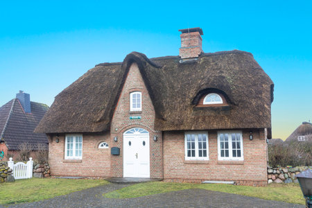 Wenningstedt, Germany - February 16, 2022: typical reed roofed house in Wenningstedt at the Island of Sylt.のeditorial素材
