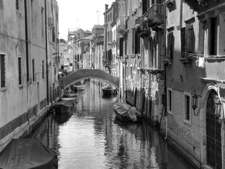 narrow canal with ships in Venice, Italyの写真素材