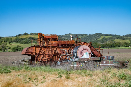 Solvang, USA - April 21, 2019: Old harvester machine at a field out of order.のeditorial素材