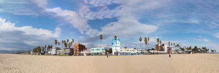Venice, USA - March 5, 2019: people enjoy scenic beach promenade with palms and colorful houses at Venice Beach in California.のeditorial素材