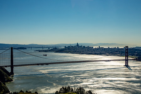 skyline of San Francisco with golden gate bridge in sunset against the sun