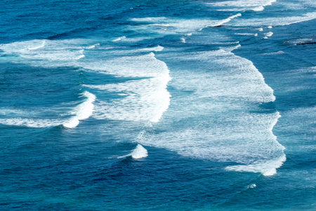 pattern of harmonic waves with spume at the beach