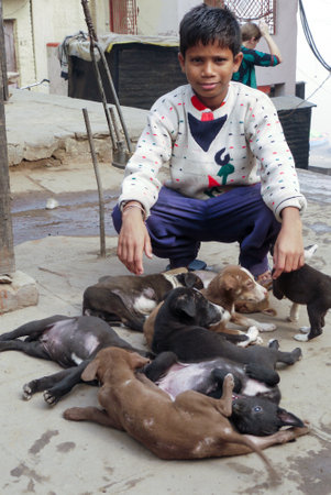 Varanasi, India - December 10, 2009: boy is selling young dogs in Varanasi, India. Dog meat is eaten in India.のeditorial素材