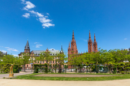 Wiesbaden, Germany - May 18, 2023: view from the market square to the old town hall of Wiesbaden and market church with green trees in foreground.のeditorial素材