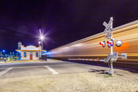 Railroad crossing by night with sign in kingmanの写真素材