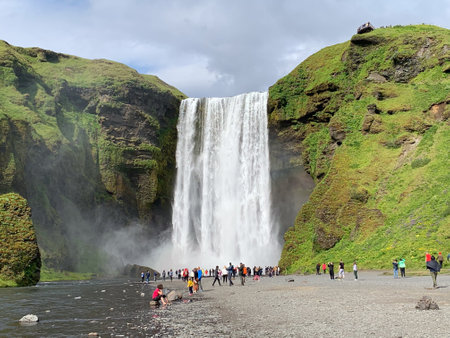 SkÃ³gafoss, Iceland -July 19, 2023: Tourists walking towards the SkÃ³gafoss waterfall in summer.のeditorial素材