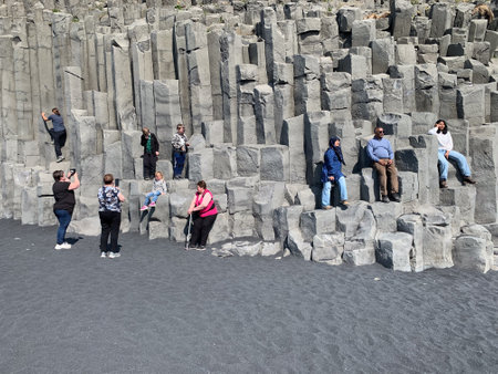 Reynisfjara, Icelang - July 19, 2023: people visit vertical basalt columns at Reynisfjara, the famous black beach in Iceland, near VÃ­k Ã­ MÃ½rdal, form a perfect geometric background patternのeditorial素材