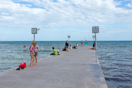 Key West, USA - August 26, 2014: People relax at concrete pier at southernmost point in Key West.のeditorial素材