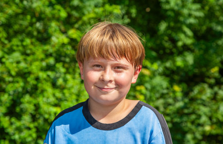 portrait of young boy with red hair in nature