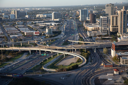 Dallas, USA - November 6, 2023: Interstate with flyover and bridges with train in late afternoon in...