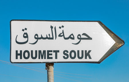 street sign to town of Houmet Souk in Djerba, Tusesia in european and arabic letter under blue skyの写真素材