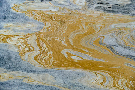 pattern of pollution in the river gives a harmonious colorful backgroundの写真素材