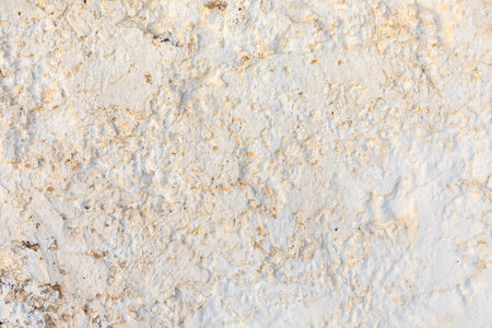 rough white plaster wall with uneven structure and old paint symbolizing time and ageの写真素材