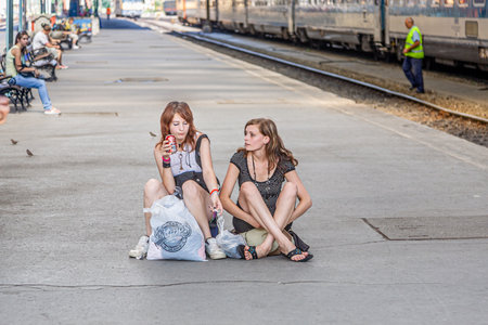 Budapest, Hungary - August 4, 2008: two girls sitting at the platform waiting at Keleti west train station in Budapest, Hungary. The Western Railway Station in Budapest was built by the Eiffel Company of Paris.のeditorial素材