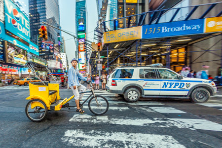 New York, USA - July 8, 2010: Rickshaw driver in early morning at Times Square, featured with Broadway Theaters and guarded by police. It is a symbol of New York City and the United States.のeditorial素材