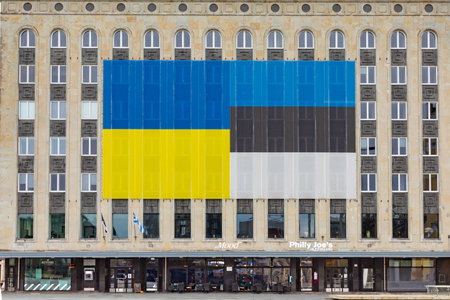 Tallinn, Estonia - October 27, 2024: Large Estonian flag at the facade of an old office building.のeditorial素材