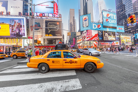 New York, USA - July 8, 2010: typical yellow cap taxi at Times Square, featured with Broadway Theaters and guarded by police. It is a symbol of New York City and the United States.のeditorial素材