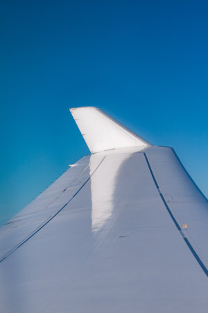 detail of wing of a modern jet as symbol for travel, vacation backgroundの写真素材