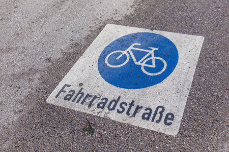 wet sign bicycle lane - german Fahrradstrasse - painted at the wet streetの写真素材