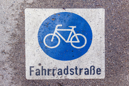 wet sign bicycle lane - german Fahrradstrasse - painted at the wet streetの写真素材