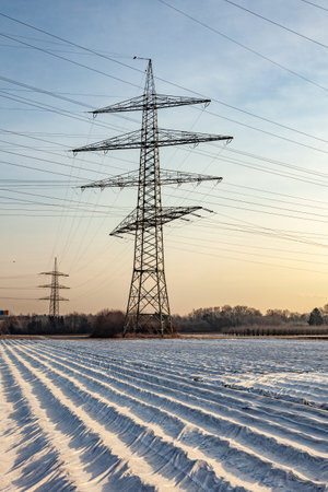Electric tower in rural landscape with fields in foil to be protected from the frostの写真素材