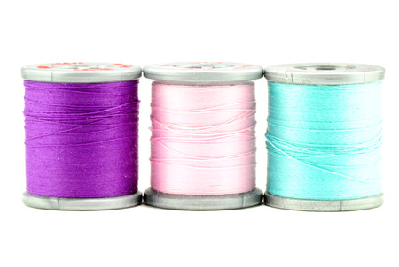 One each spool of purple, pink, and blue threadの写真素材