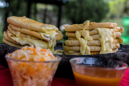 typical Salvadoran dish, cheese pupusas with cabbage and tomato sauce. rice and corn pupusas stuffed with cheese, beans or other ingredientsの写真素材