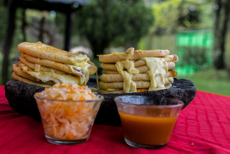 typical Salvadoran dish, cheese pupusas with cabbage and tomato sauce. rice and corn pupusas stuffed with cheese, beans or other ingredientsの写真素材