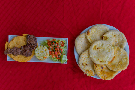 typical Salvadoran dish, cheese pupusas with cabbage and tomato sauce. rice and corn pupusas stuffed with cheese, beans or other ingredientsの写真素材