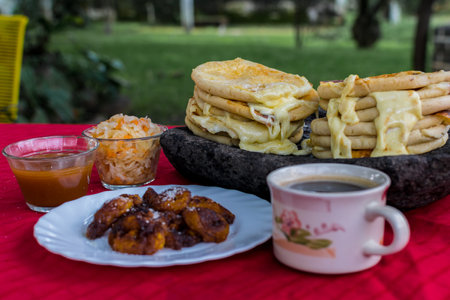 typical Salvadoran dish, cheese pupusas with cabbage and tomato sauce. rice and corn pupusas stuffed with cheese, beans or other ingredientsの写真素材