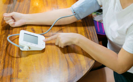 young woman measuring blood pressure and heart rate at homeの写真素材