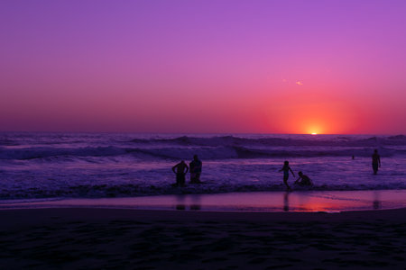 Silhouette of people walking on the beach at sunset time. people bathing in one of the most famous beaches in El Salvador. sunset on a beachの写真素材
