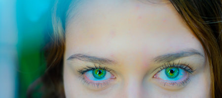 Close up portrait of beautiful young woman with green eyes looking at cameraの写真素材