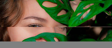 Close up portrait of a young woman with green eyes and monstera leaf. face of a beautiful young...