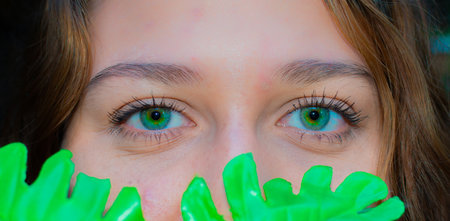 Close-up portrait of a beautiful young woman with green eyes.