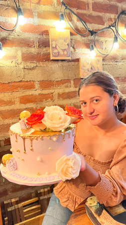 Beautiful young woman with a cake in her hands. A girl with a cake in her hands. Cake with roses.の写真素材