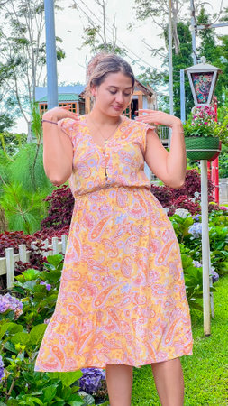 Miss with green eyes enjoying in a beautiful garden with flowers of many colors, wearing a long, fresh dress. Concept of outdoor walks and fresh airの写真素材